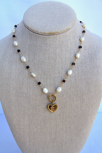 Necklace with heart-shaped pendant on a mannequin bust against a light blue background
