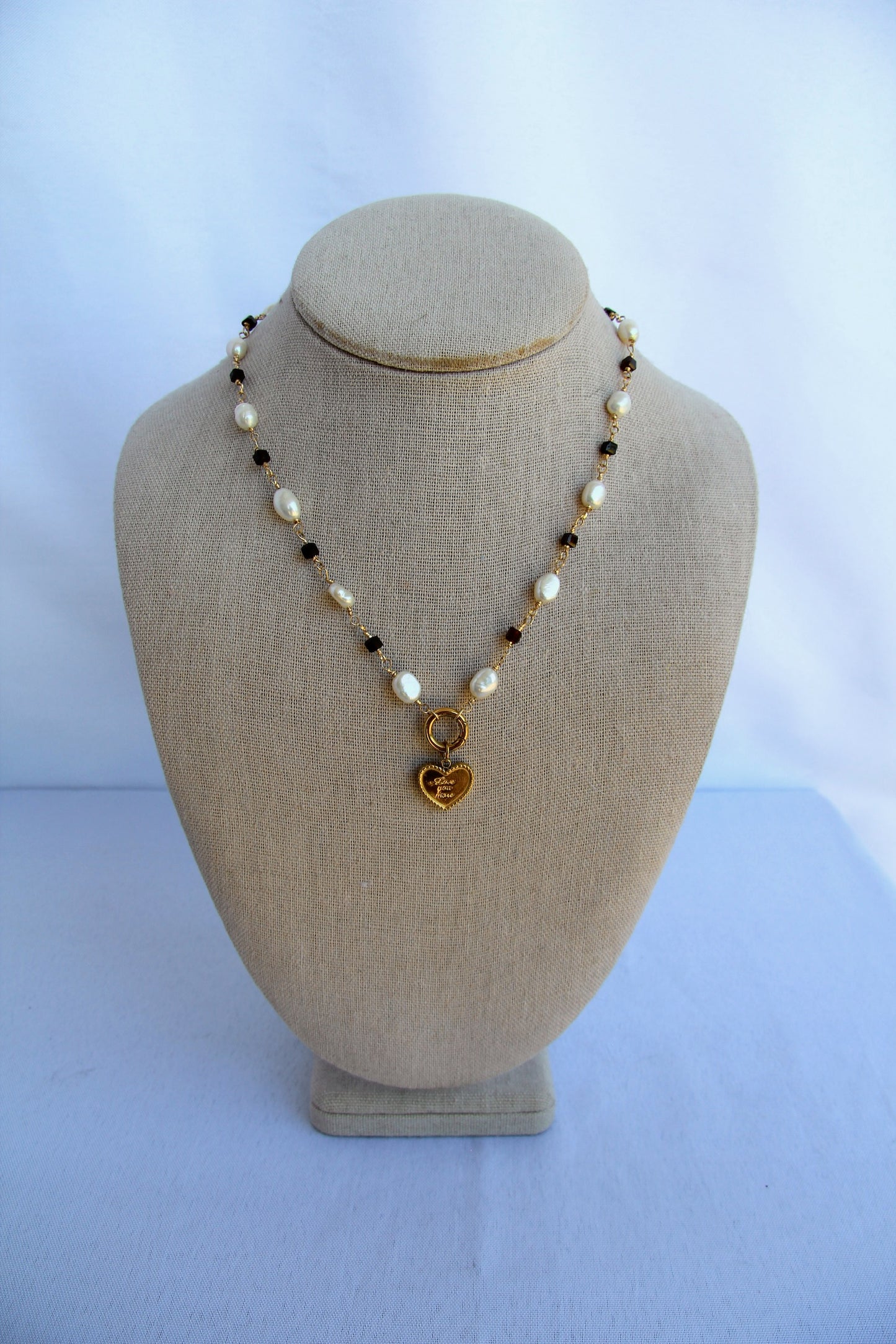 Necklace with heart pendant on a mannequin bust against a white background